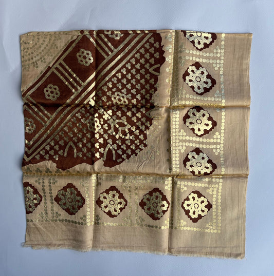 Decorative fabric with brown and gold patterns on a beige background.