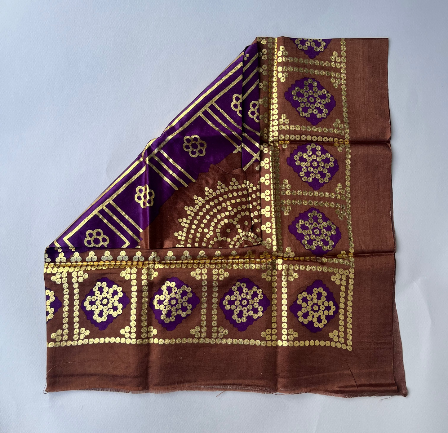 Brown fabric with gold and purple floral pattern.
