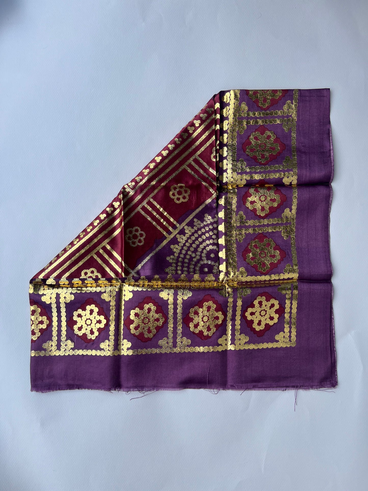 Purple fabric with gold patterns.