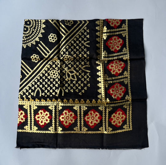 Black fabric with gold and red patterns.