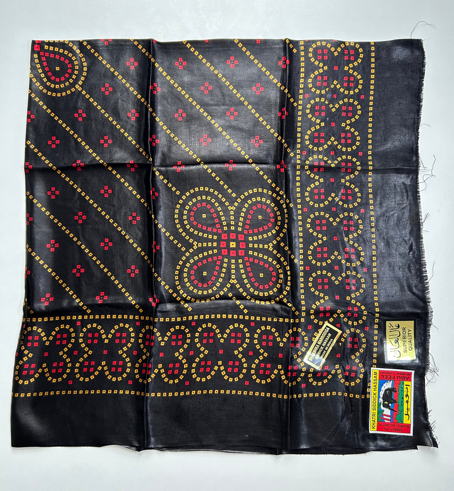 Black fabric with red and gold patterns.